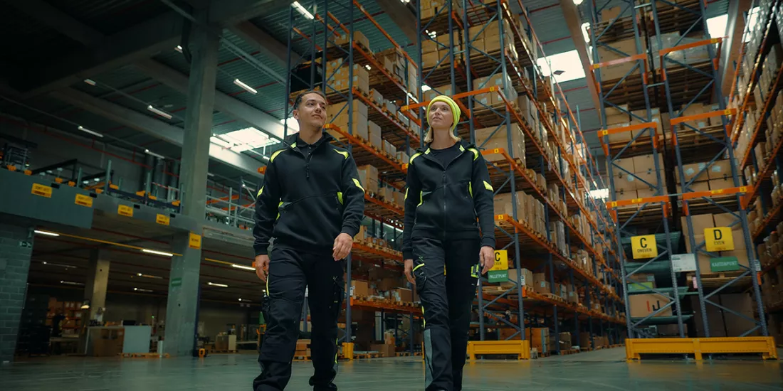 2 Magazijnmedewerkers in KMO-magazijn met palletstellingen voor efficiënter magazijnbeheer